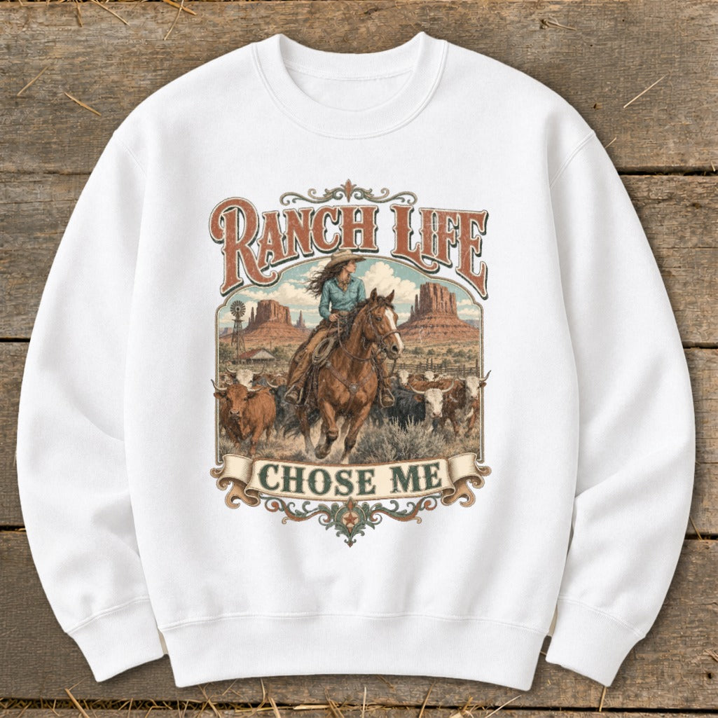 White sweatshirt with graphic featuring a cowboy on horseback herding cattle, text reads "RANCH LIFE CHOSE ME".