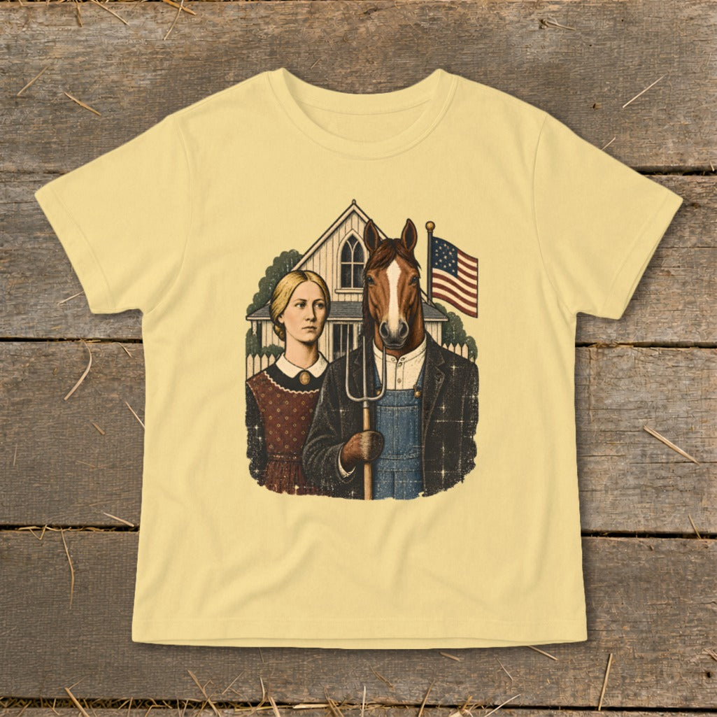 A light yellow t-shirt with a satirical graphic featuring a woman and a horse holding a pitchfork in front of a farmhouse.