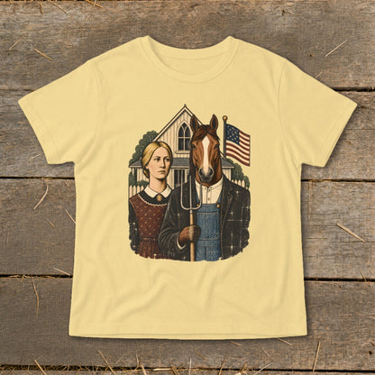 A light yellow t-shirt with a satirical graphic featuring a woman and a horse holding a pitchfork in front of a farmhouse.