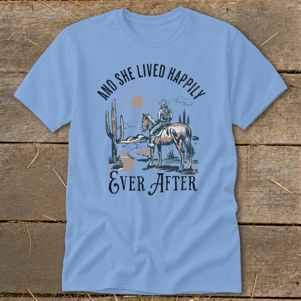 Light blue t-shirt with desert scene and text "And She Lived Happily Ever After".