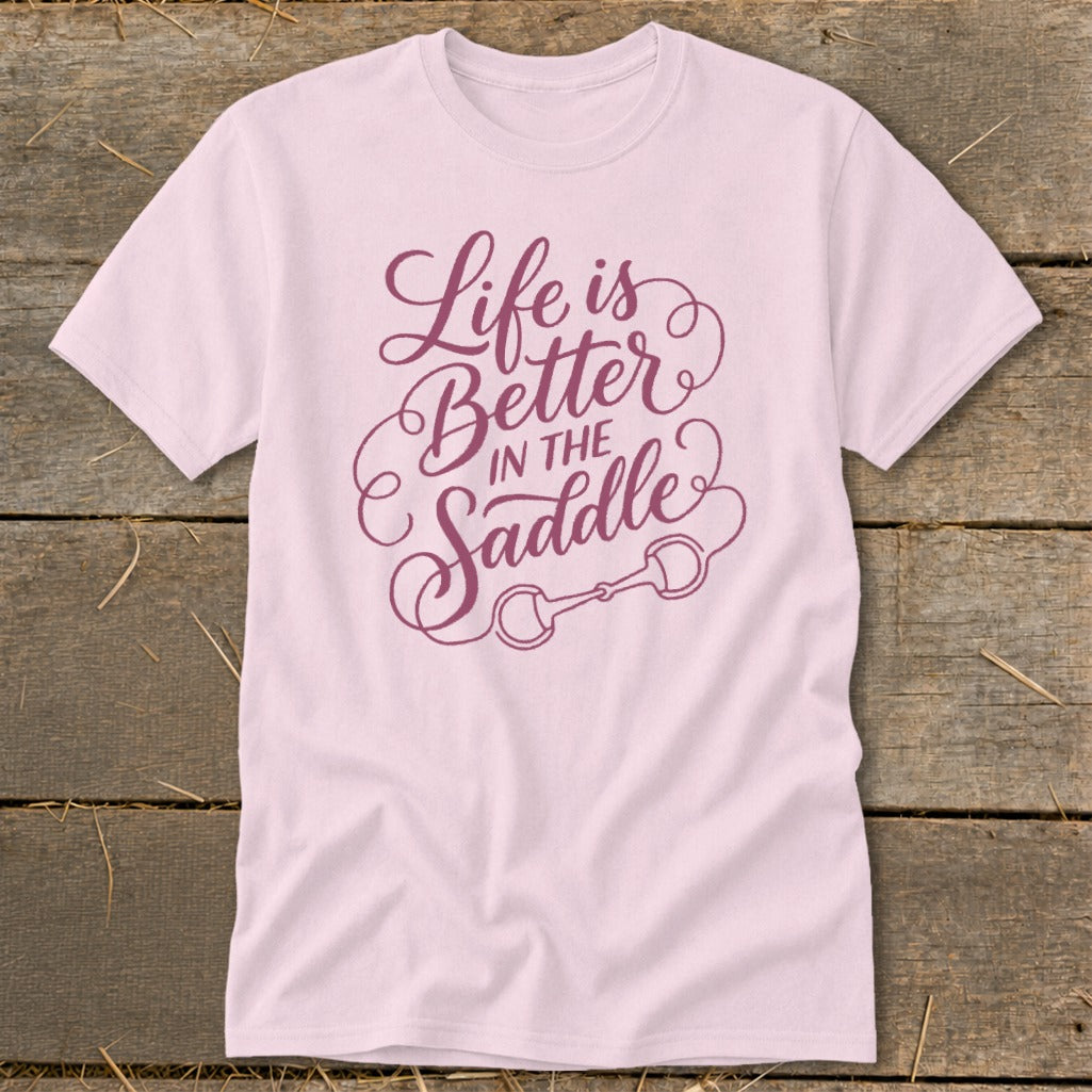 Light pink t-shirt with purple text that reads "Life is Better in the Saddle".