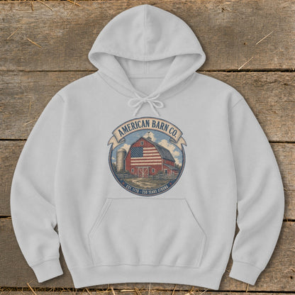 White hoodie with circular American Barn Co. logo featuring a red barn and American flag.