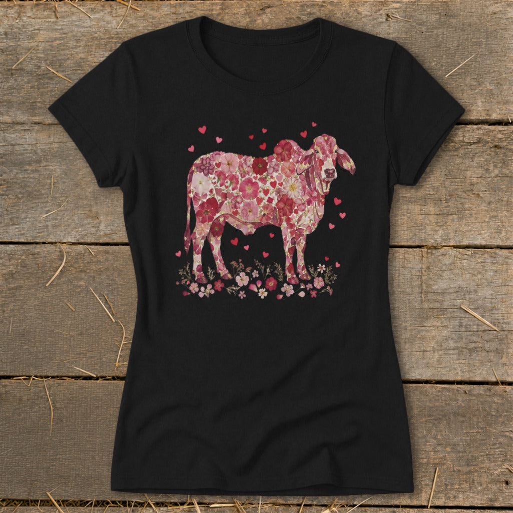 Black t-shirt featuring a floral print cow with hearts and flowers.