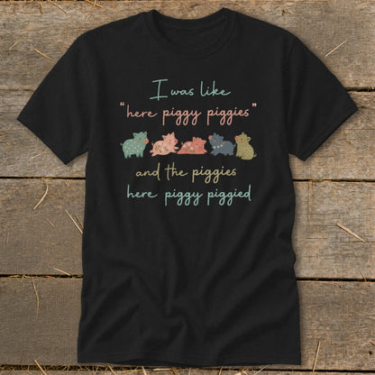 Black t-shirt with a graphic of five cartoon pigs and the text "I was like "here piggy piggies" and the piggies here piggy piggied".
