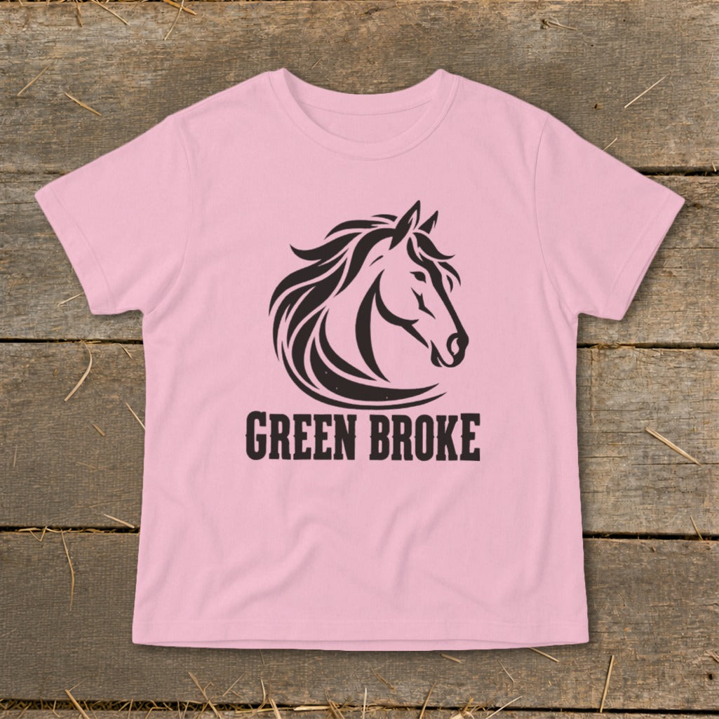 A light pink t-shirt with a black graphic of a horse's head and the text "GREEN BROKE".