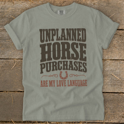 Light gray t-shirt with "UNPLANNED HORSE PURCHASES ARE MY LOVE LANGUAGE" text and horseshoe graphic.