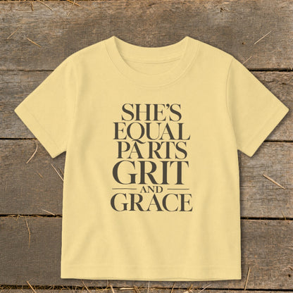 Light yellow t-shirt with "She's Equal Parts Grit and Grace" text in dark gray.