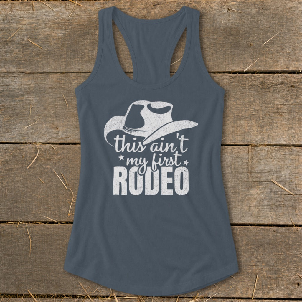 Grey tank top with white cowboy hat graphic and text "this ain't my first RODEO".