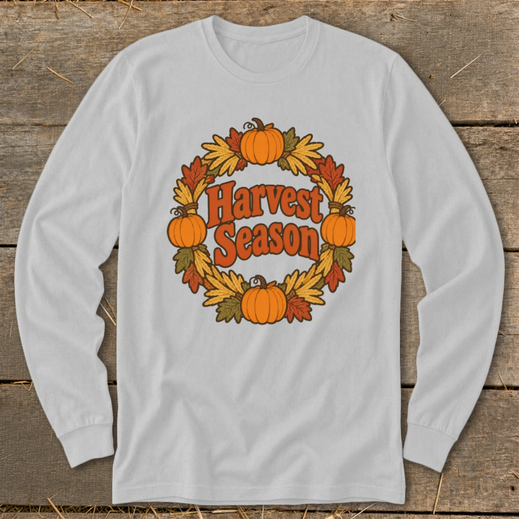 White long-sleeve shirt with "Harvest Season" text and pumpkin wreath graphic.