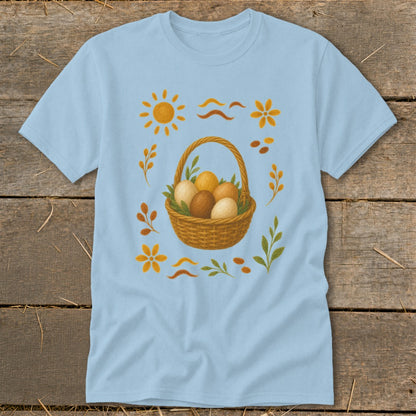 Light blue t-shirt with a wicker basket of eggs and spring-themed illustrations.