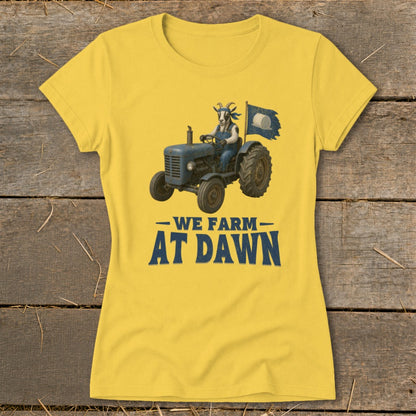 Yellow t-shirt with graphic of goat driving tractor and text "WE FARM AT DAWN."