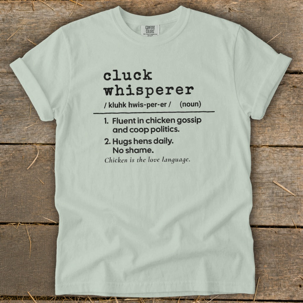 Light blue t-shirt with "cluck whisperer" definition and chicken imagery.