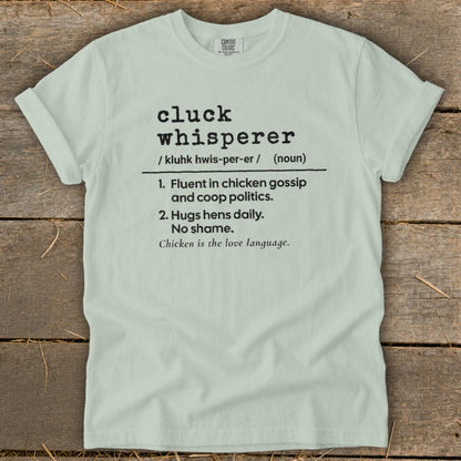 Light blue t-shirt with "cluck whisperer" definition and chicken imagery.