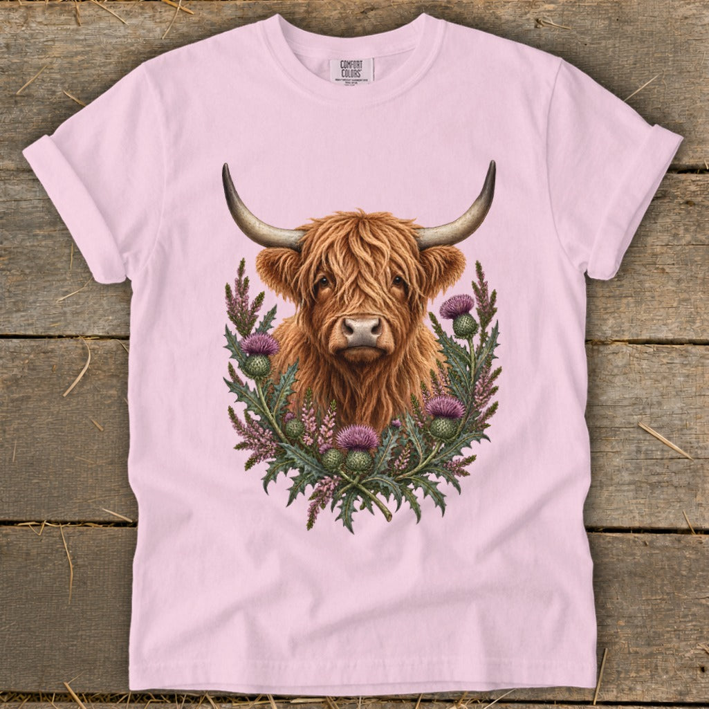 Pink t-shirt with a Highland cow and thistles graphic.