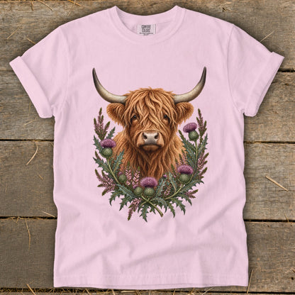 Pink t-shirt with a Highland cow and thistles graphic.