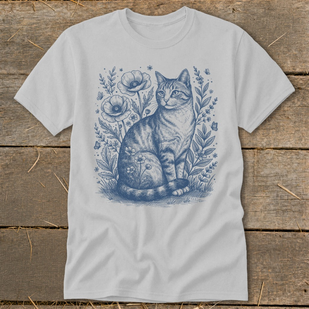 Blue sketch of a tabby cat sitting among flowers and butterflies on a white t-shirt.