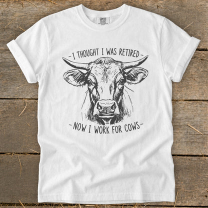 White t-shirt with sketch of cow and text "I thought I was retired - Now I work for cows".