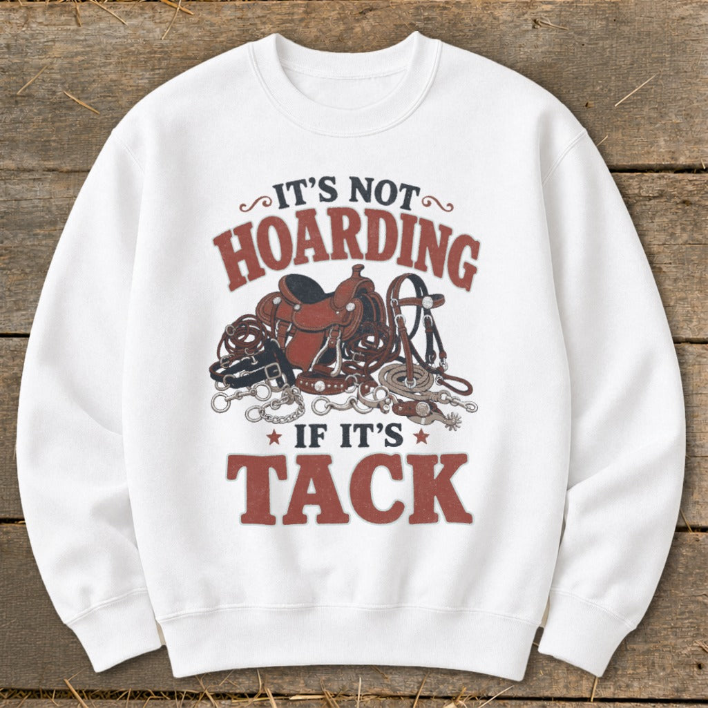 White sweatshirt with "It's not hoarding if it's tack" text and horse tack graphic.