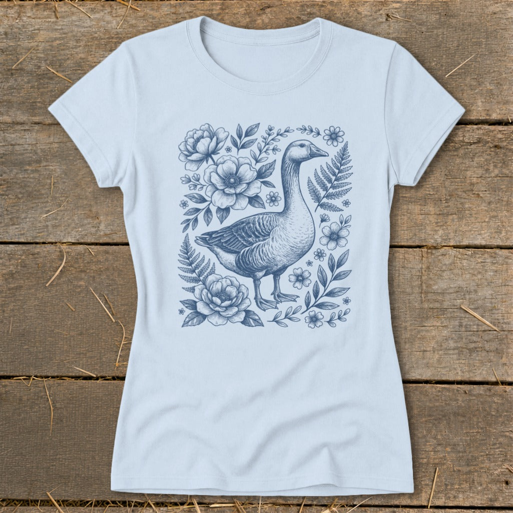 Light blue t-shirt with a blue line drawing of a goose surrounded by flowers and ferns.