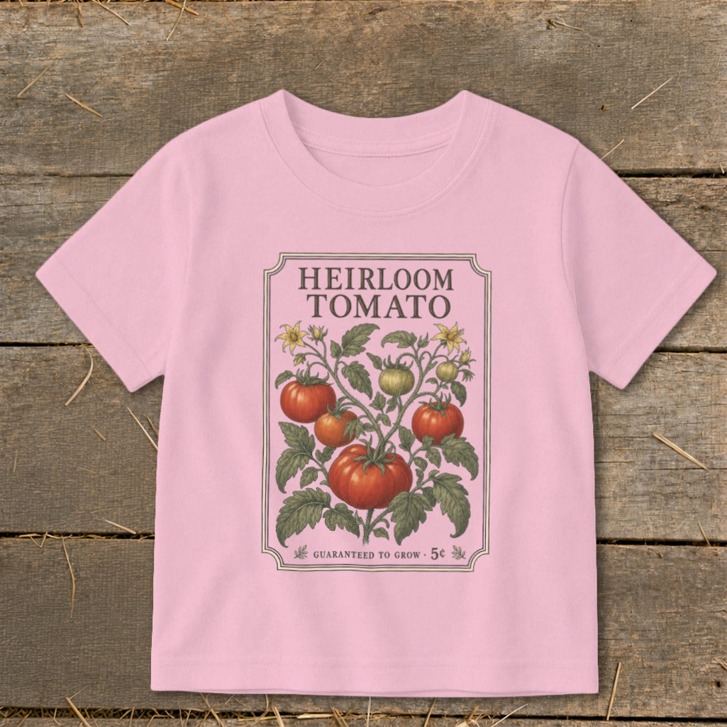 Pink t-shirt with "Heirloom Tomato" seed packet design featuring tomatoes and flowers.