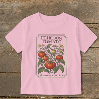 Pink t-shirt with "Heirloom Tomato" seed packet design featuring tomatoes and flowers.