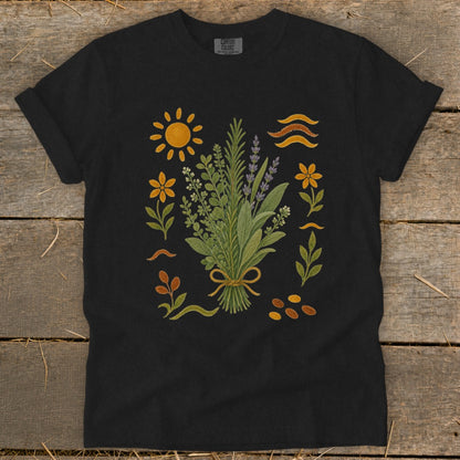 Black t-shirt with a central bouquet of herbs, sun, flowers, and wavy lines.