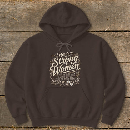 Brown hoodie with "Here's to Strong Women" text and floral accents.