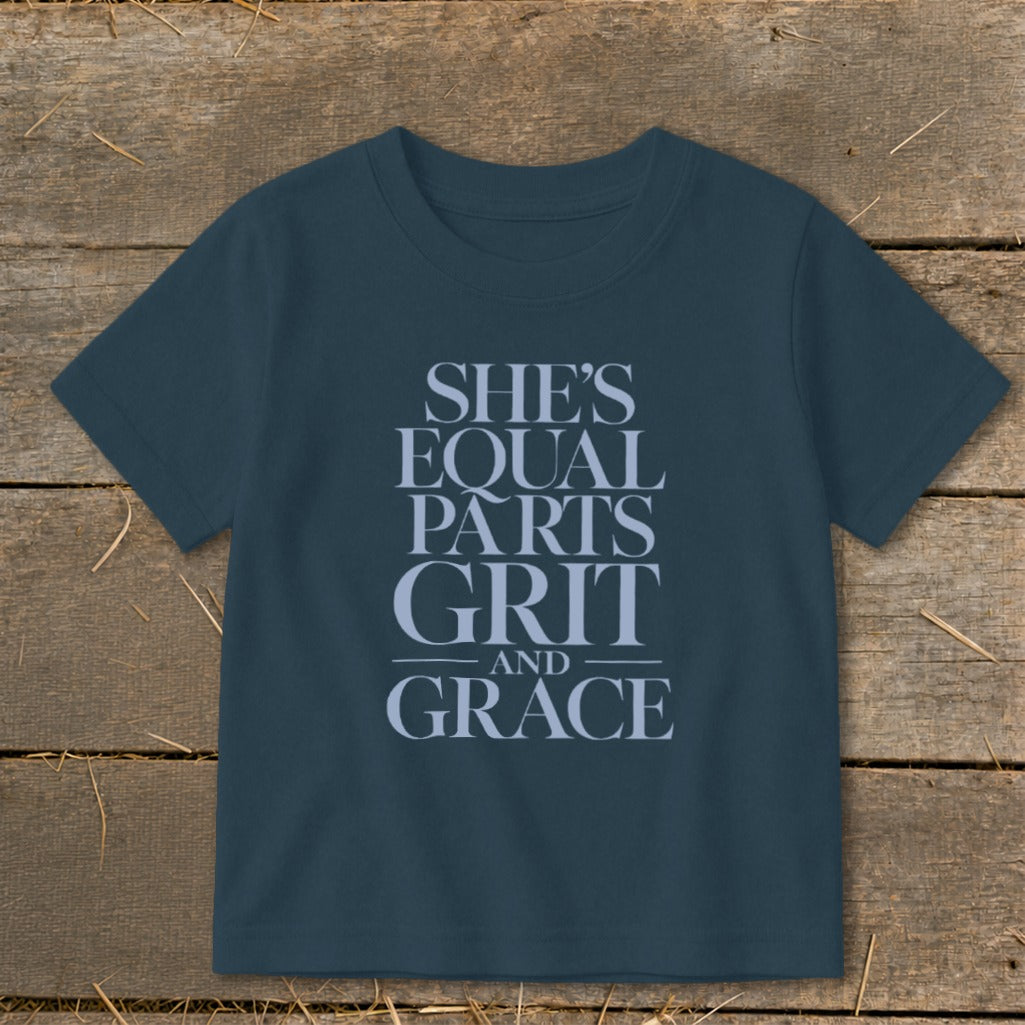 Dark blue t-shirt with "She's equal parts grit and grace" text.
