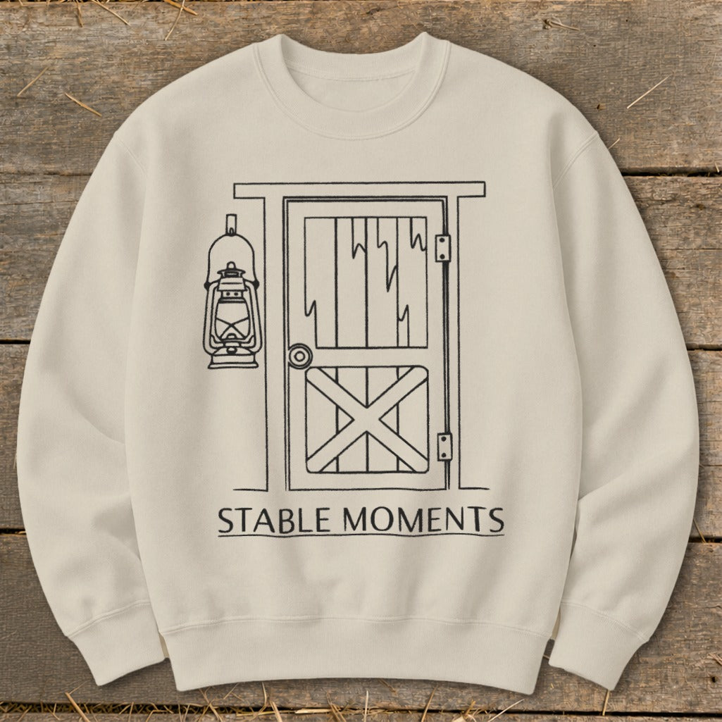 Cream sweatshirt with line art of barn door, lantern, and text "STABLE MOMENTS".