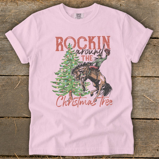 Pink t-shirt with "Rockin Around The Christmas Tree" text and rodeo scene.