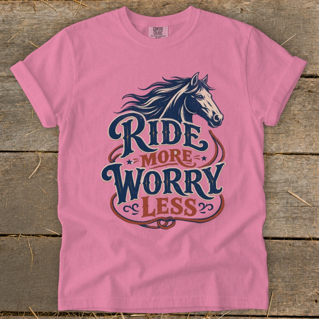 Pink t-shirt with a horse graphic and text reading "Ride More Worry Less".