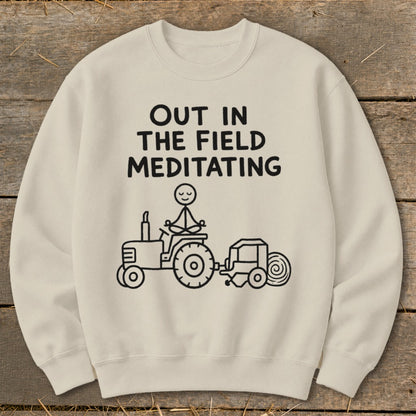 Cream sweatshirt with black text and drawing of stick figure meditating on tractor.