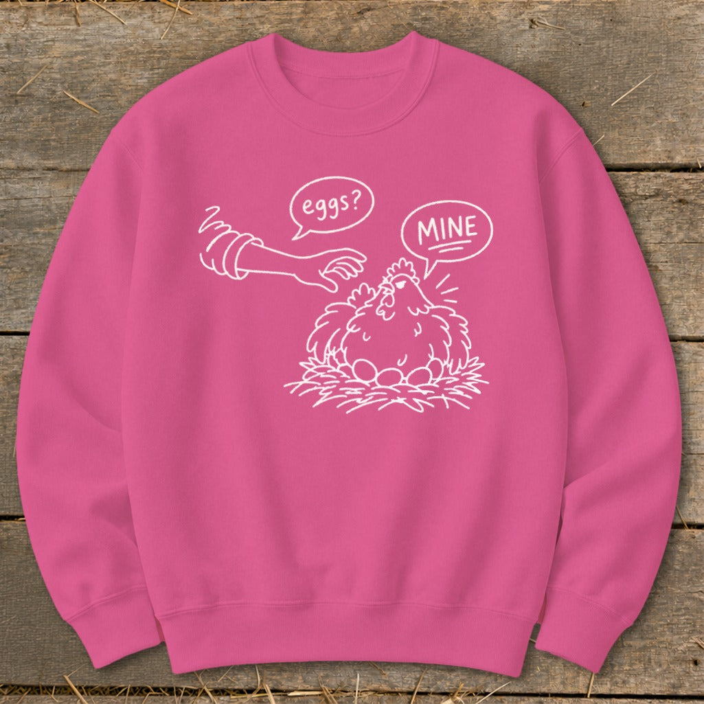Pink sweatshirt with a white line drawing of a hen protecting eggs, asking "eggs?" and "MINE".