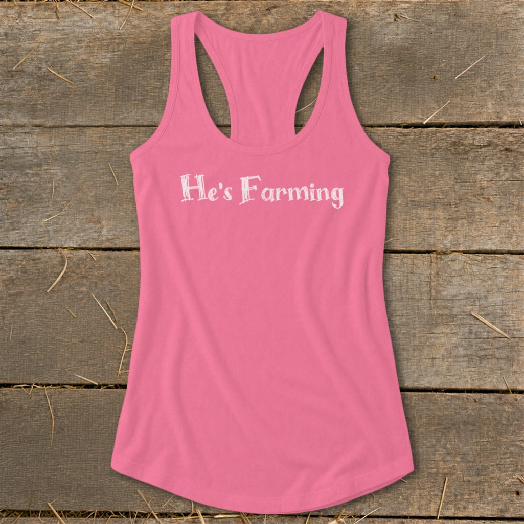 Pink racerback tank top with white text "He's Farming"