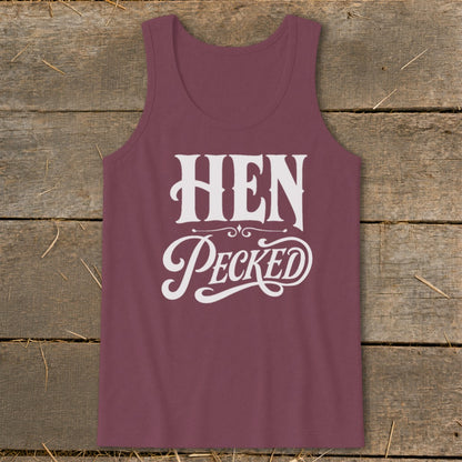 Maroon tank top with white text "HEN Pecked" on rustic wood background.