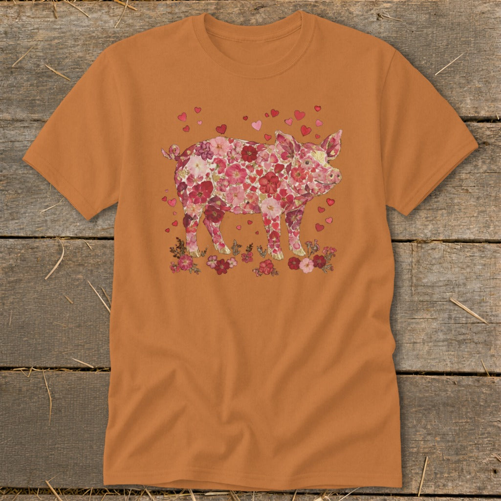 Orange t-shirt with a pig covered in flowers and hearts on the chest.
