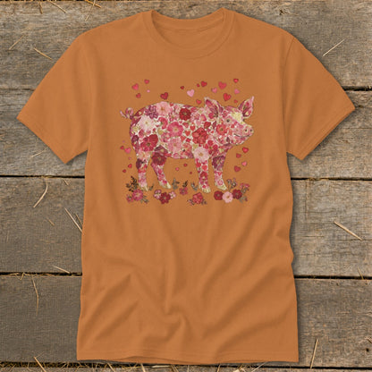 Orange t-shirt with a pig covered in flowers and hearts on the chest.