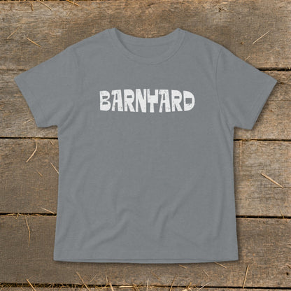 A gray crewneck t-shirt with distressed white text reading BARNYARD centered on the chest, laid flat on a rustic wooden background.