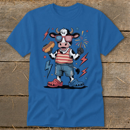 Cartoon cow in patriotic attire holding a hot dog and sparkler.