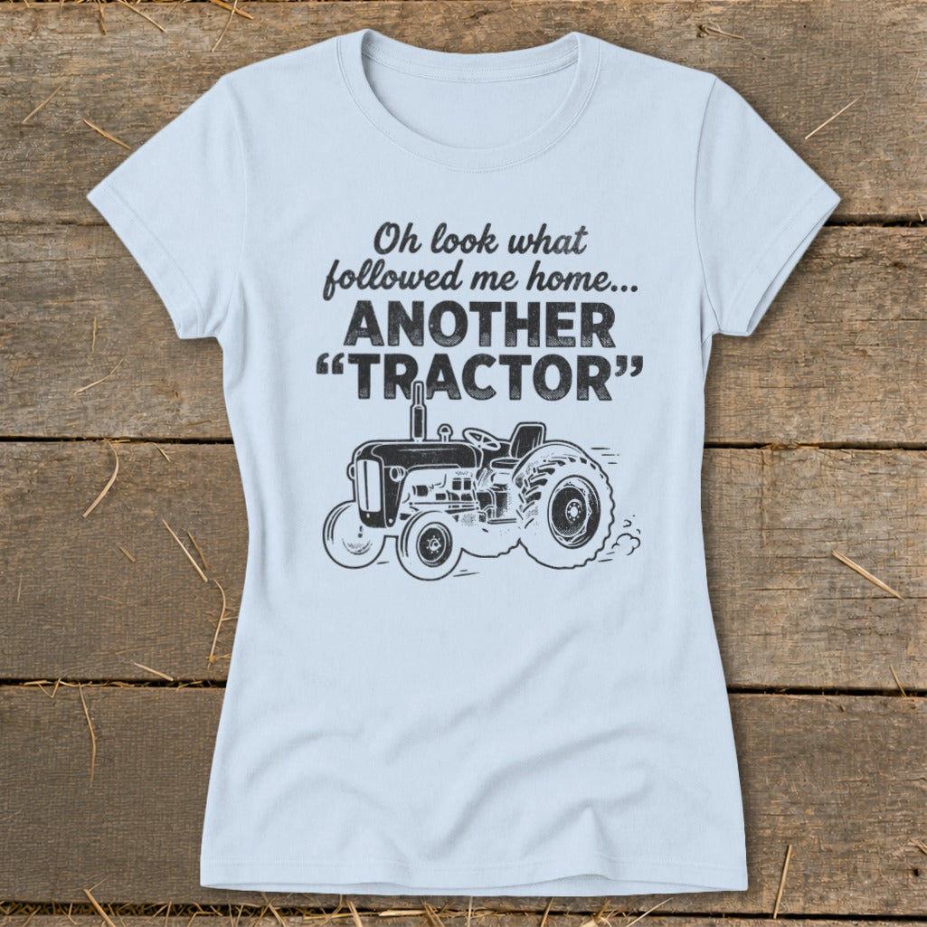 Light blue t-shirt with text "Oh look what followed me home... ANOTHER 'TRACTOR'" and tractor graphic.