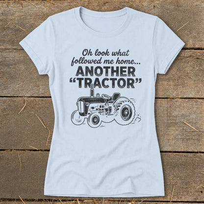 Light blue t-shirt with text "Oh look what followed me home... ANOTHER 'TRACTOR'" and tractor graphic.