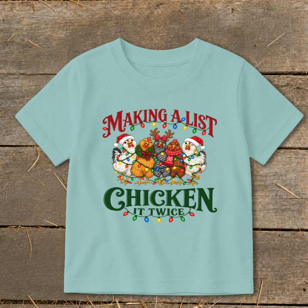 Light blue t-shirt with chickens in Santa hats and Christmas lights, "Making a list, chicken it twice" text.