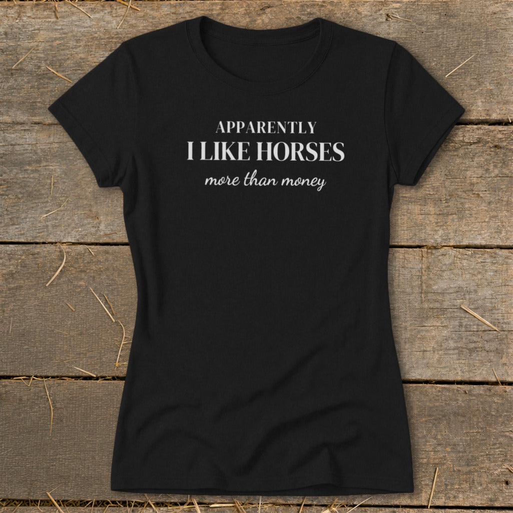 Black t-shirt with white text: "APPARENTLY I LIKE HORSES more than money"