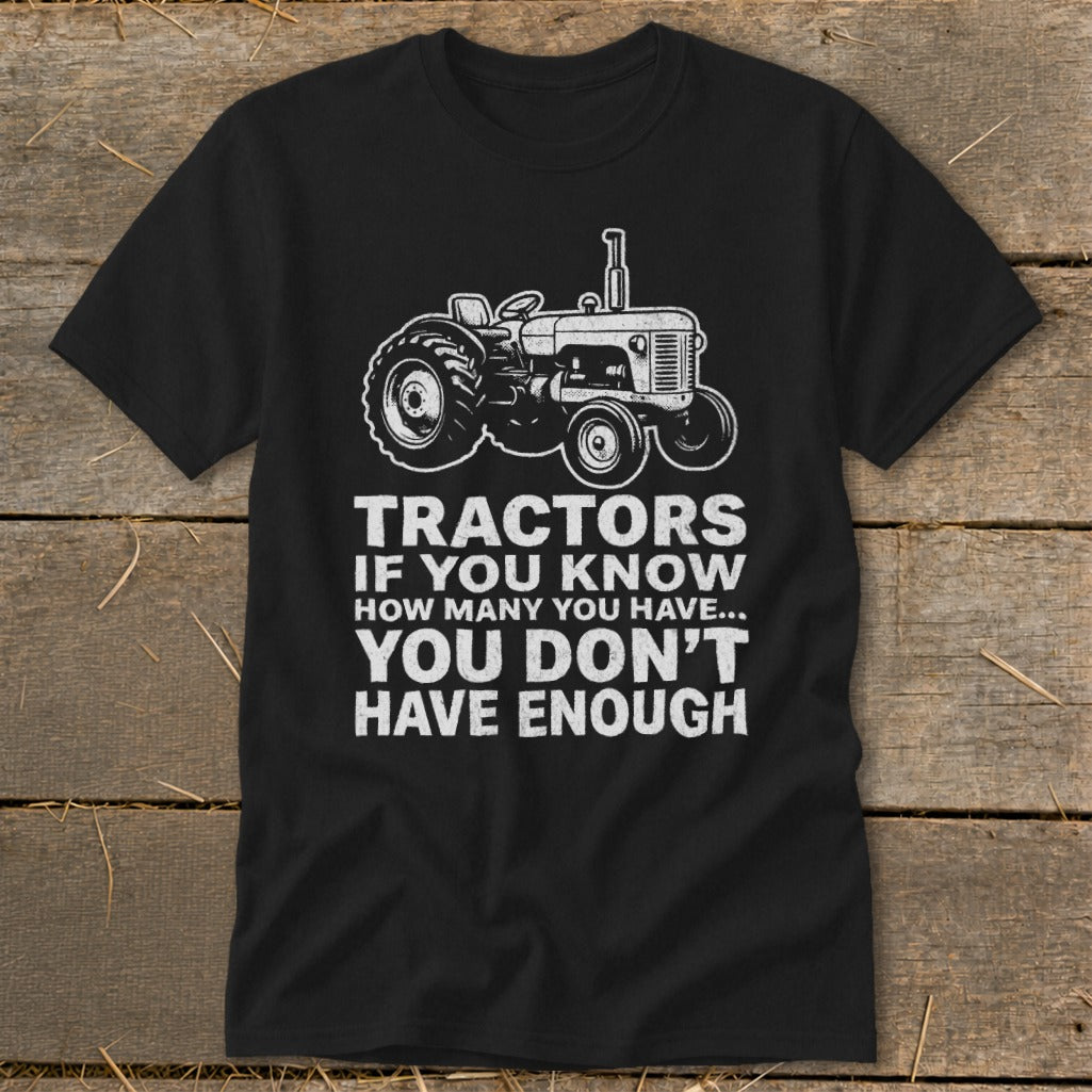 Black t-shirt with white tractor graphic and text "Tractors if you know how many you have... you don't have enough."
