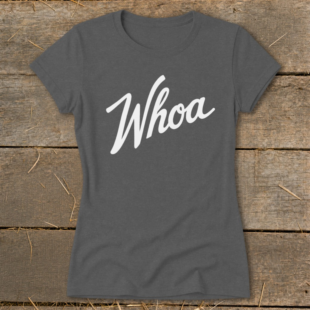 Dark grey t-shirt with "Whoa" in white cursive font on rustic wood background.