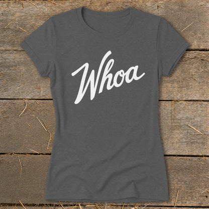 Dark grey t-shirt with "Whoa" in white cursive font on rustic wood background.