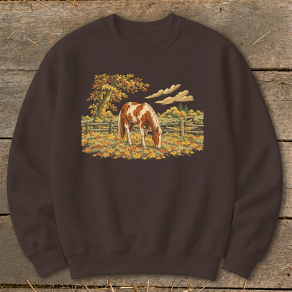 Brown sweatshirt with a pinto horse grazing in a fall field.