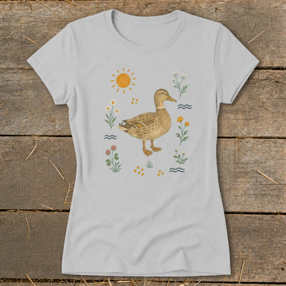 Light gray t-shirt with a watercolor duck surrounded by flowers, sun, and waves.