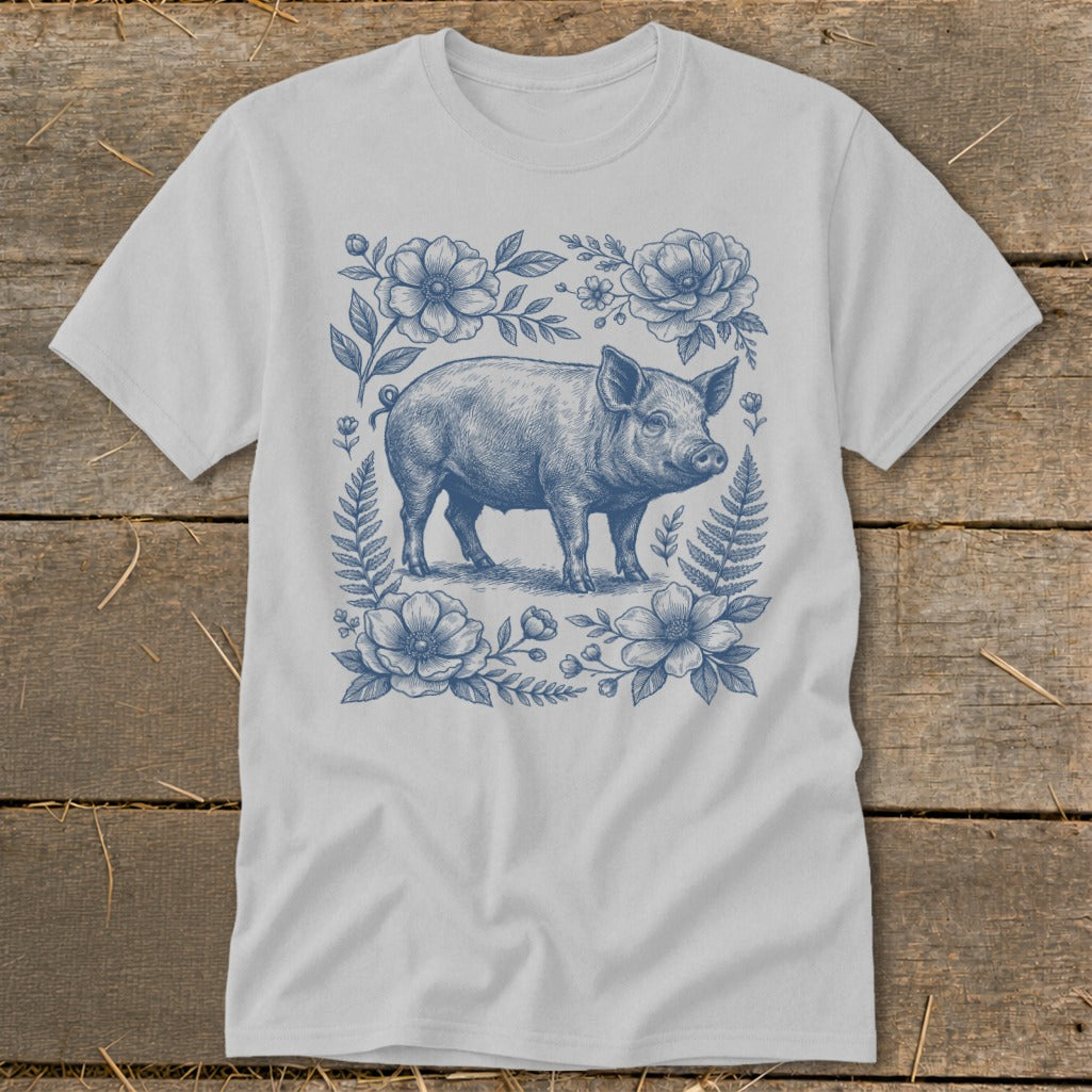 Light grey t-shirt with a blue line drawing of a pig surrounded by flowers and leaves.