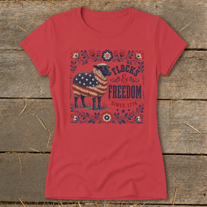 Red t-shirt with a sheep wearing the American flag and text "Flocks & Freedom Since 1776".